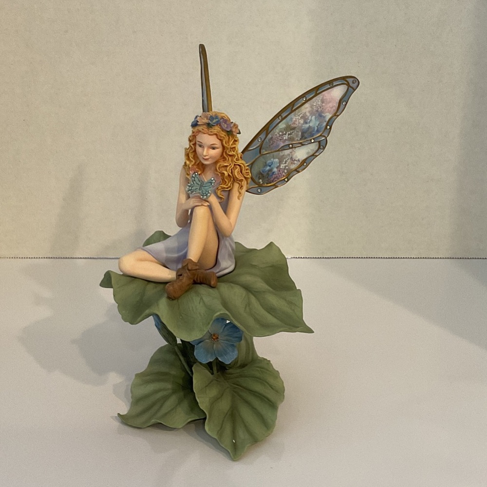 Whimsical Fairy Sculpture with Blue Wings and Green Leaves